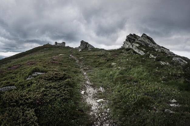 Carpathian mountains summer landscape with dramatic sky and old observatory on the top, natural travel background