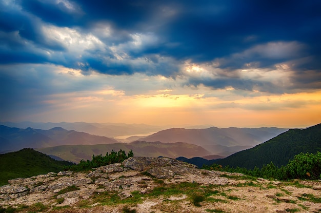 Carpathian mountains summer sunrise landscape with dramatic sky, rocks and sun shining