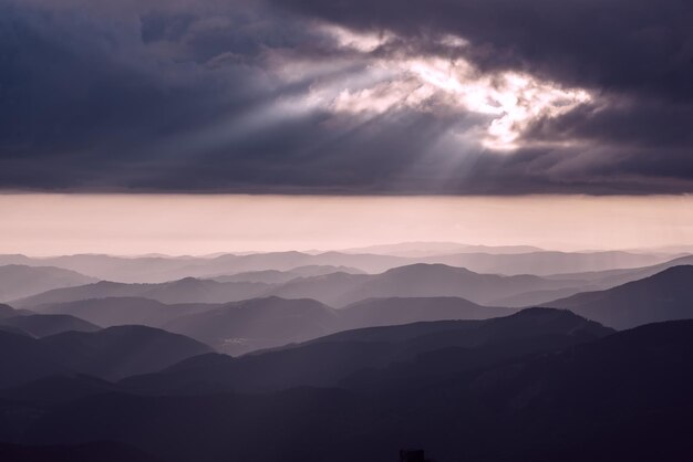 Карпатские горы летний закат пейзаж с абстрактным градиентом горных вершин и драматическим небом с солнечными лучами, естественный фон для путешествий