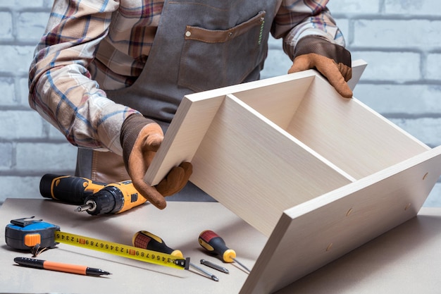 Carpenter Assembling Furniture On Desk Or Workbench DIY concept