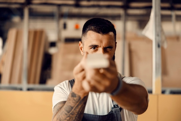 A carpenter checking on wood at workshop