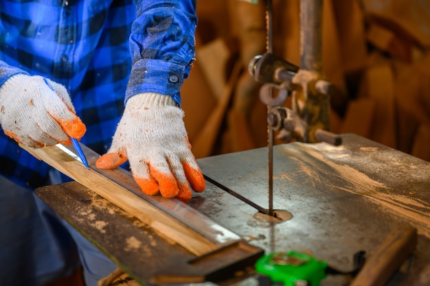 Carpenter or craftsman Use a circular saw to saw the wood. In workshop Carpentry office background.