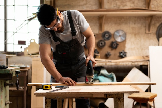 Carpenter cutting mdf board inside workshop