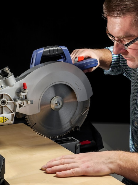 Carpenter cutting wood with circular saw