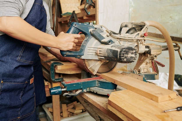 Carpenter cutting wooden board