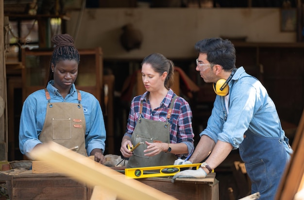 Photo carpenter and his assistant working together in a carpentry workshop