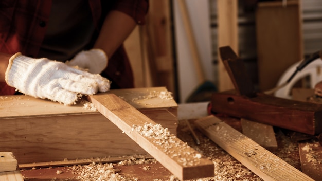 Photo carpenter holding pieces of board at site.