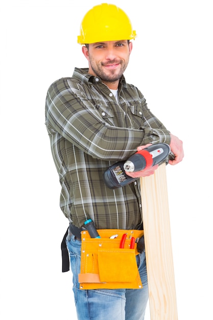 Carpenter holding power drill and wood plank