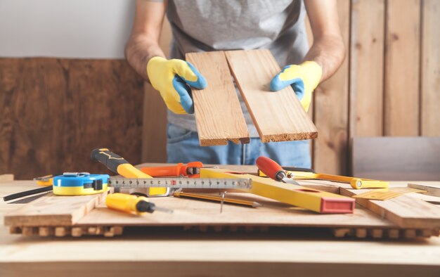 Carpenter holding wooden planks. Woodworking industry