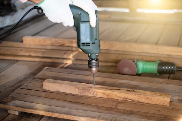 Carpenter is drilling with punching machine