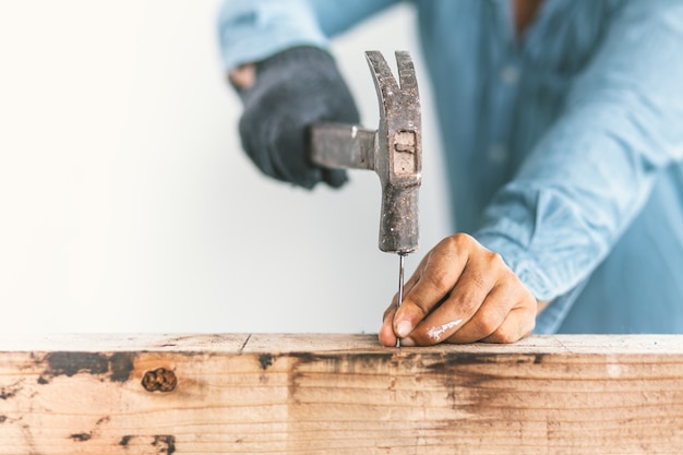 The carpenter is repairing the house. 