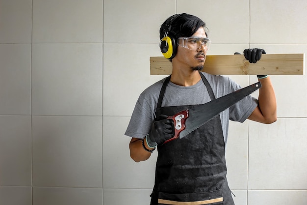 Carpenter man holding saws and wood