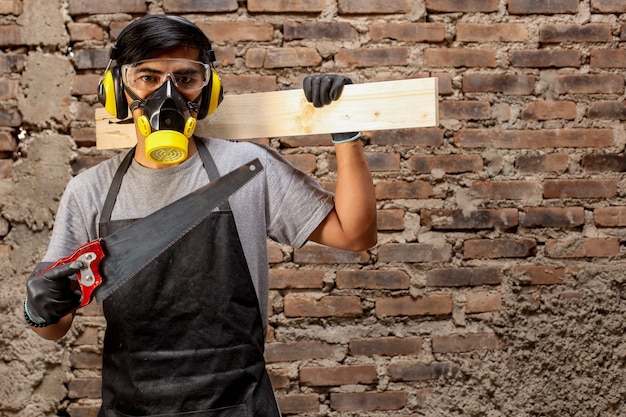 Carpenter man holding saws and wood