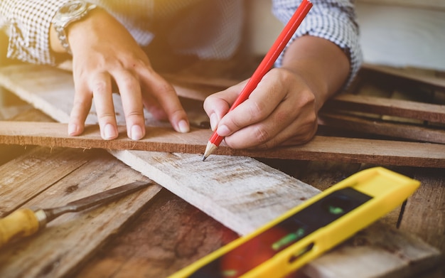 Foto misura uomo carpentiere in legno con la matita.