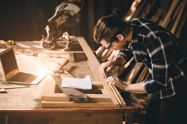 Foto falegname uomo lavoratore del legno che lavora mobili fatti a mano in negozio industria fabbrica artigiano in legno maschio builder che lavora in officina con progettazione assistita da computer