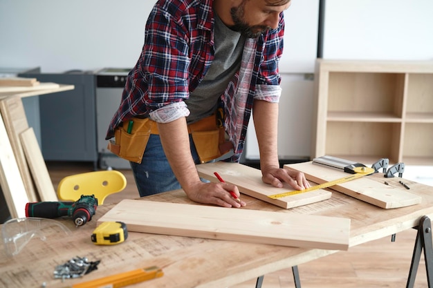 Carpenter measures the boards at the table