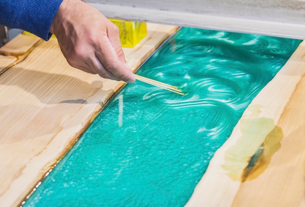 carpenter mixes epoxy to create a tracery on the kitchen table