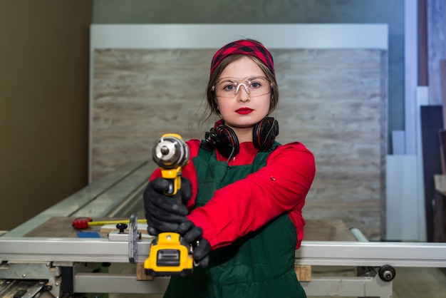 Carpenter posing with drill machines, woodworker - woman