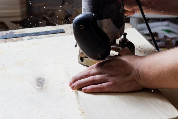 carpenter processes wood on a machine