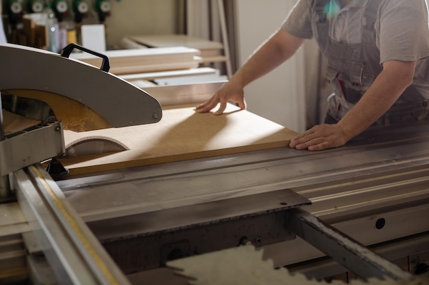 Carpenter processes wooden beam on plane machine