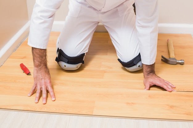 Carpenter putting down new wooden planks