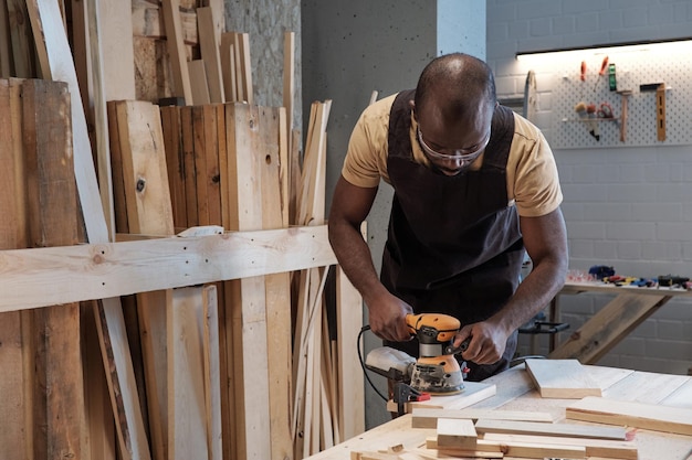 Carpenter sanding wood in workshop