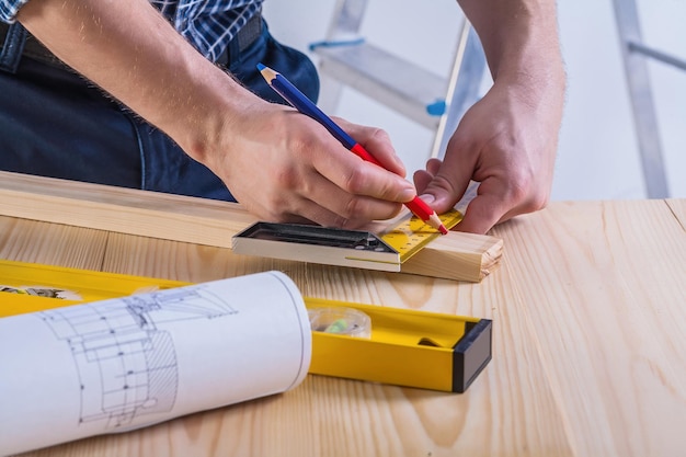 Carpenter sketching wooden plank very close up view