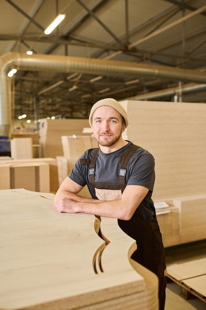 Carpenter standing with finished wooden products