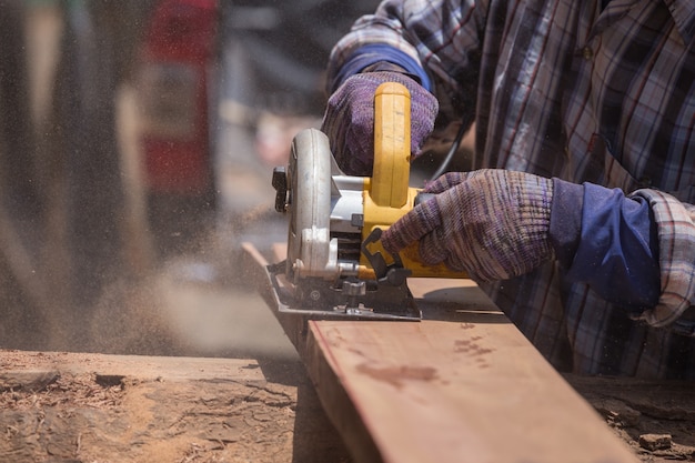 carpenter use electric saw to sawing wood