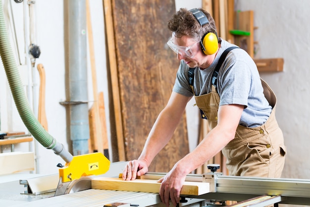 Carpenter using electric saw in carpentry