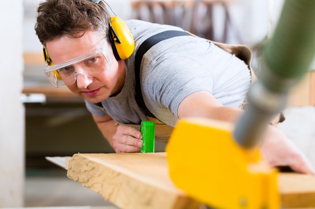 Carpenter using electric saw in carpentry