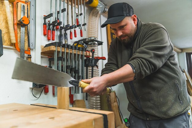 Carpenter using a handsaw to cut wood