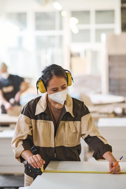 Carpenter using ruler at her work