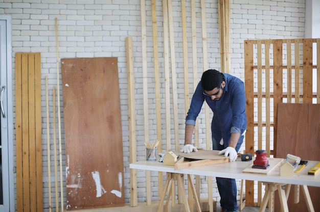 Carpenter or warehouse worker choosing raw wood material for the work at the carpentry storage