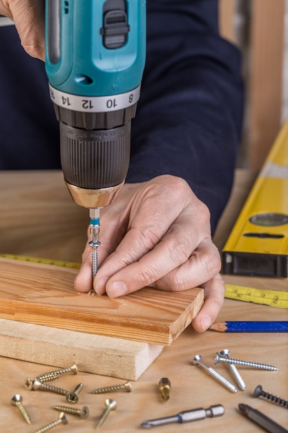 Carpenter with an electric screwdriver. carpenter at handmade work.