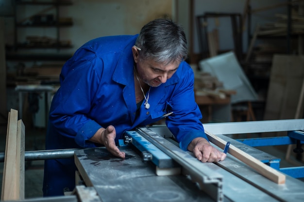 Carpenter at work at his workshop, wood processing 