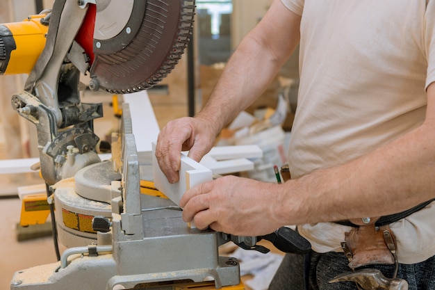Carpenter working cutting molding by circular saw