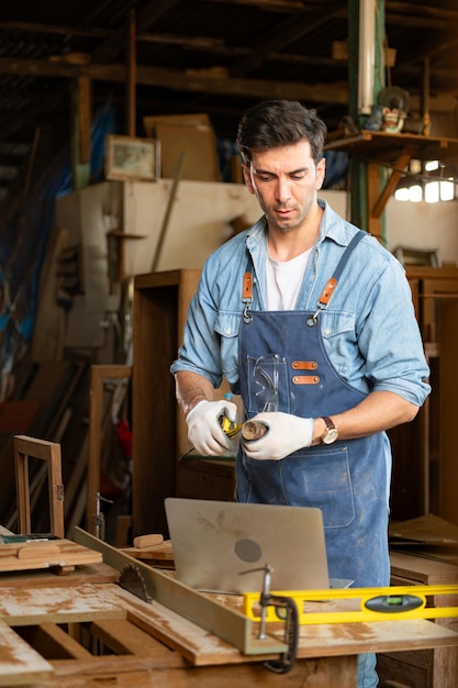 Carpenter working at his carpentry shop Eyesight is utilized to ensure accuracy