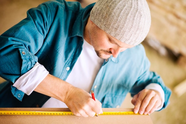 Foto falegname che lavora su una tavola di legno nella sua officina