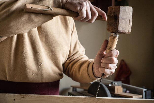 写真 木製のハンマーとゴージで作業する木工