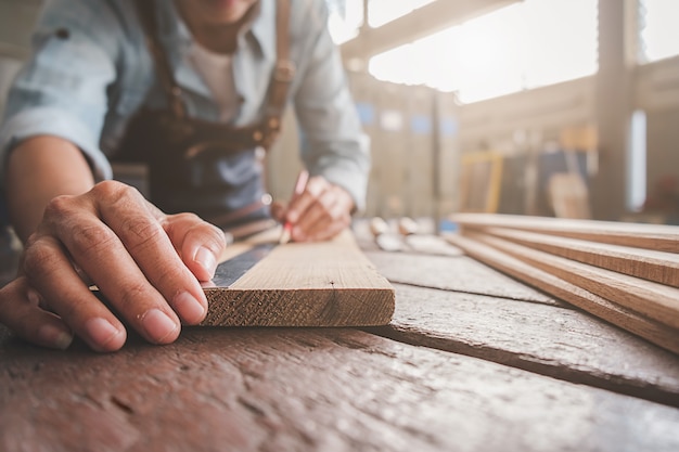 Carpenter working with equipment on wooden table in carpentry shop. woman works in a carpentry shop. 