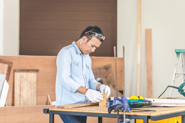 Carpenter working with equipment on wooden table in wood workshop Technical man doing woodwork in carpentry shop