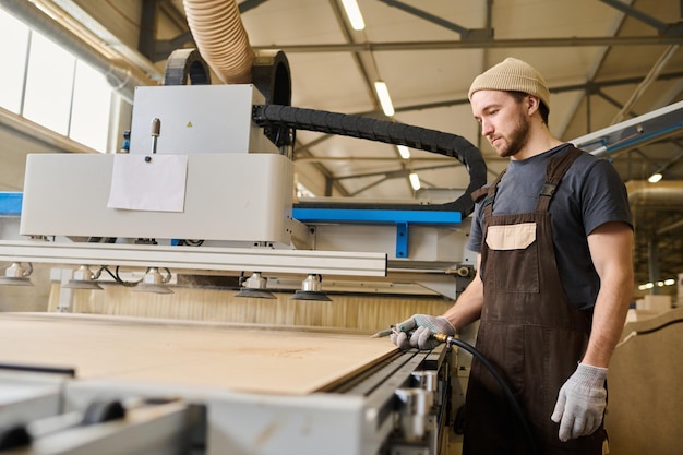 Carpenter working with timber at machine