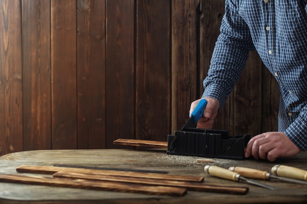 Photo carpenter working with tools on wooden wall