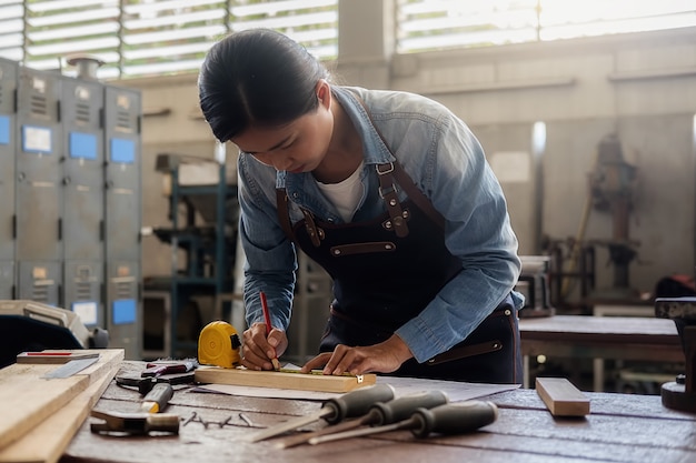 Carpenter working on woodworking machines in carpentry shop