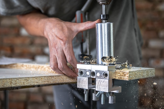 The carpenter works as a professional tool for drilling wood.