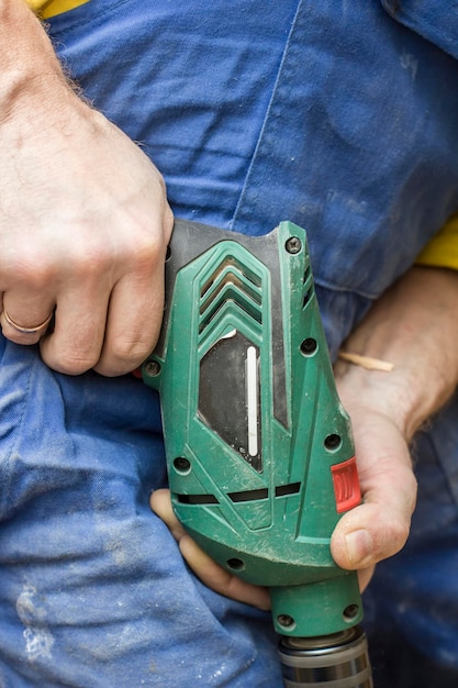 Carpenter works with the electric drill