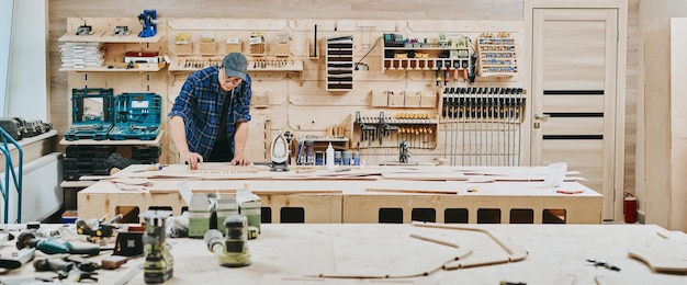 Foto il falegname lavora con il legno nel laboratorio di falegnameria uomo che lavora il legno in modo professionale