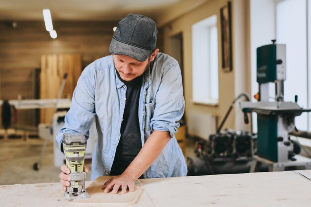 Carpenter works with wood in carpentry workshop Man doing woodwork professionally