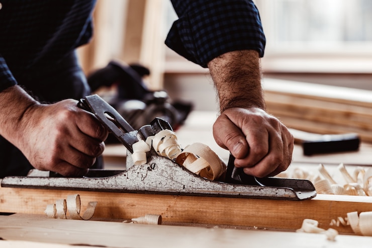 Photo carpenters hands planing a plank of wood with a hand plane